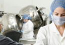 three people inside factory wearing masks and coats